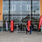 Menschen stehen vor den Eingangstür und reden miteinander