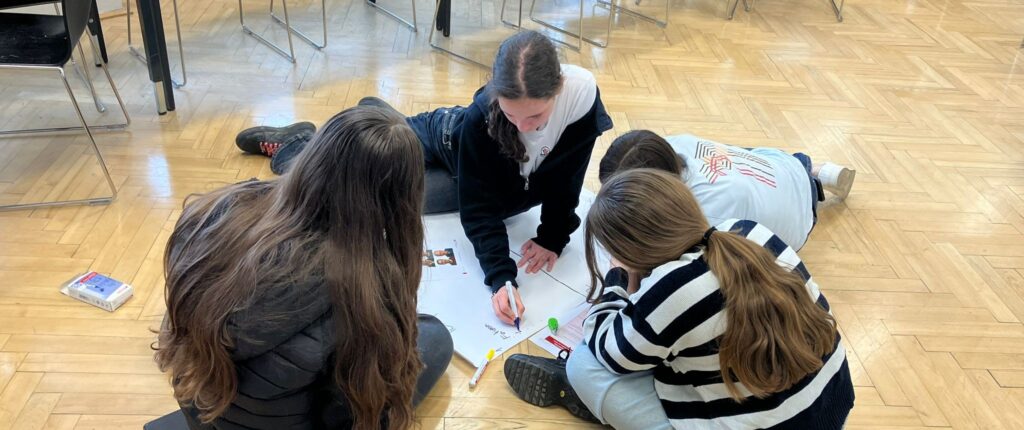 a groupof young people sitting around the poster
